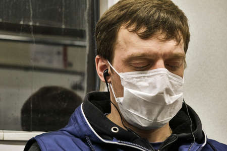 Russia Moscow June 2020. Moscow metro. a man in a protective mask rides in a subway car with his eyes closed. coronavirus epidemic in Russia. viral risk of infection. colorのeditorial素材