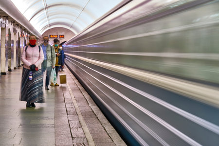 Russia Moscow June 2020. Moscow metro. effect of long exposure of the metro train movement. on the platform are people in protective masks. coronavirus epidemic in Russia. viral risk of infection. colorのeditorial素材