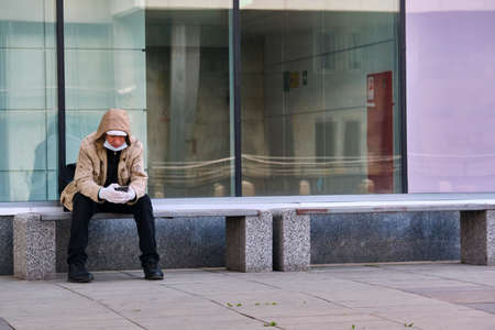 Moscow June 2020 a man in a Medical mask sits on a bench near the entrance to the lobby of the Station Mitz Lokomotiv. The Corona Virus Epidemic in Russiaのeditorial素材