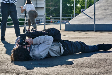 Photographer in an unusual pose takes a picture. general plan.