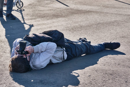 Photographer in an unusual pose takes a picture. general plan.