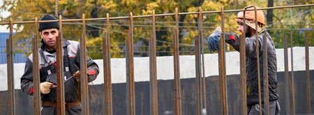 Russia / Moscow - September 2020: bridge builders stand behind an iron fence. without medical masks, but keeping a social distance. the risk of infection with coronavirusのeditorial素材