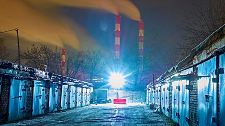 Dark urban downtown city alley at night with garbage trash bins, car garage doors. low light. colorの写真素材