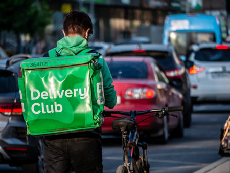 russia moscow 2021. A Courier On A Bicycle Delivers Food Around The City. the courier rides in a stream of pedestrians, without a helmet. security problems on the sidewalk in russiaのeditorial素材