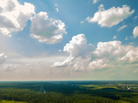 Drone view of blue sky with white clouds over forest on sunny summer dayの写真素材