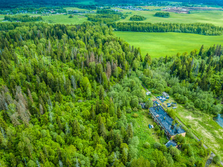 top view of an abandoned house in a wild forest. there are cars parked nearbyの写真素材