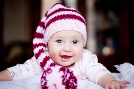cute baby in a striped purple hat with pompomの写真素材