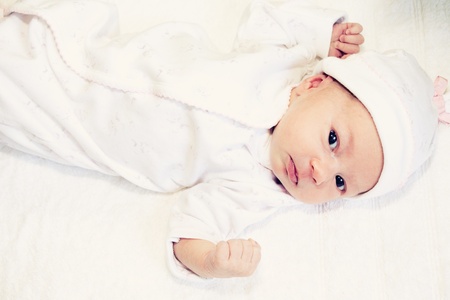 two weeks old baby girl on a white towelの写真素材