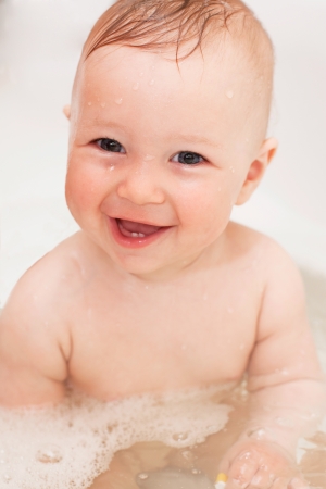 Adorable bath baby with soap suds on hairの写真素材