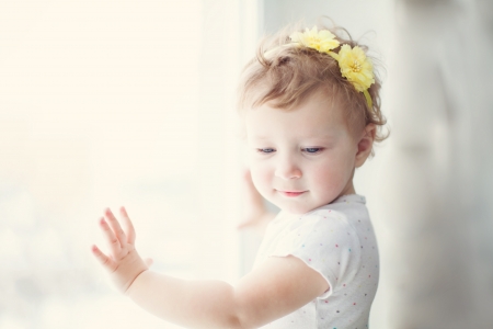 baby girl with yellow flowers in her hairの写真素材
