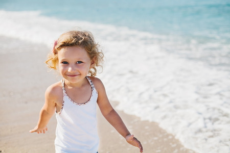 Adorable happy smiling little girl on beach vacationの写真素材