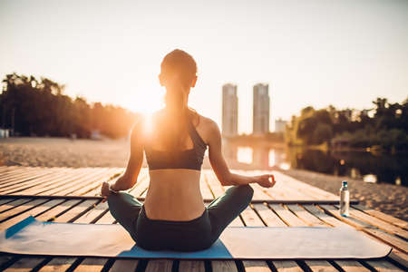sportswoman meditating at sunriseの写真素材