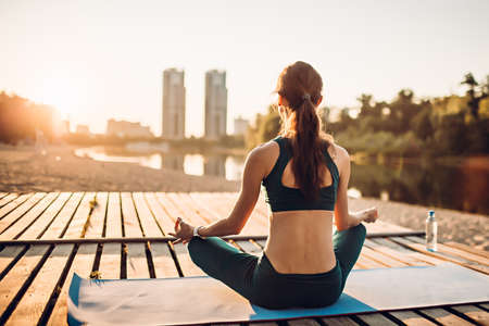 sportswoman meditating at sunriseの写真素材