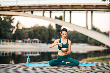 Sportswoman meditating with tibetan bellの写真素材
