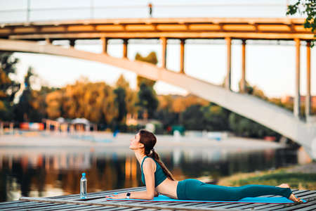 Sportswoman do yoga on wooden platformの写真素材