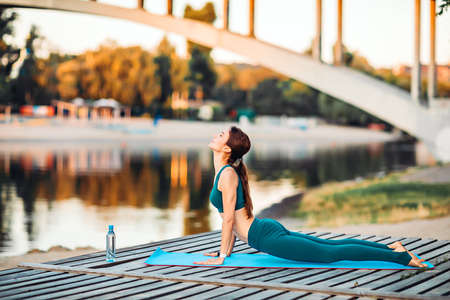Sportswoman do yoga on wooden platformの写真素材