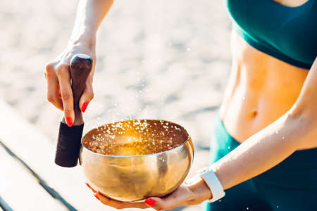 sportswoman meditating with tibetan bellの写真素材