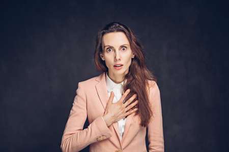 Shocked adult caucasian woman on dark backgroundの写真素材