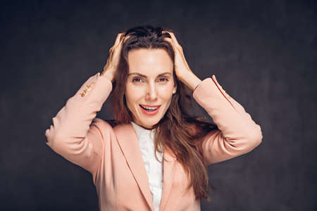 Excited adult caucasian woman on dark backgroundの写真素材