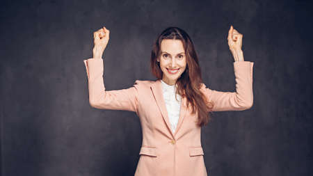 Successful caucasian woman on dark backgroundの写真素材