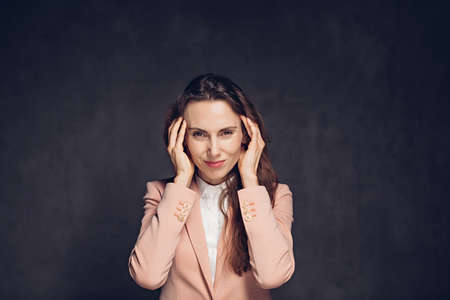 Caucasian woman with migraine on dark backgroundの写真素材