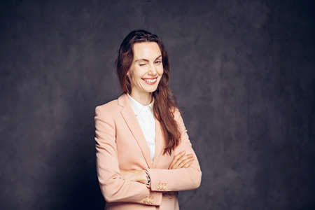 Winking adult caucasian woman on dark backgroundの写真素材