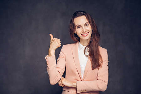 caucasian woman show thumb up on dark backgroundの写真素材