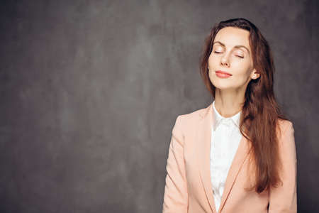 Adult woman with closed eyes on dark backgroundの写真素材
