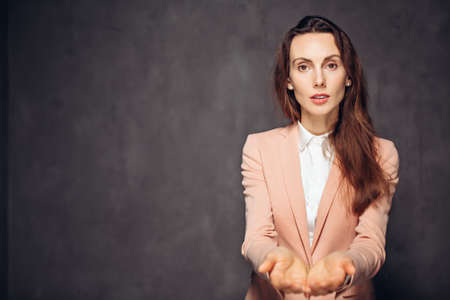 Adult woman outstretched hands on dark backgroundの写真素材