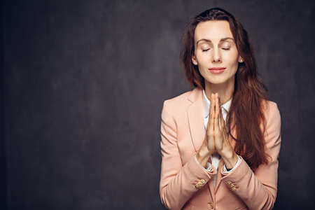 Adult woman with please gesture on dark backgroundの写真素材