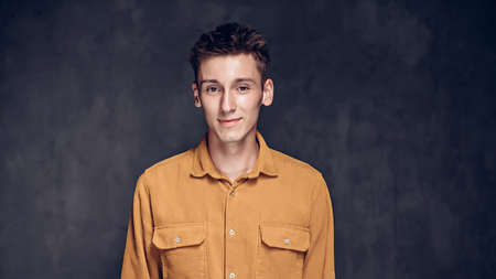 Smiling young caucasian man on dark backgroundの写真素材