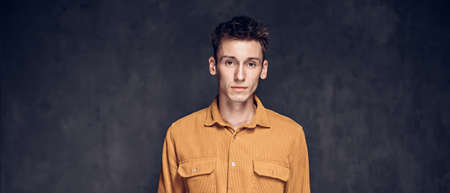 Focused young caucasian man on dark backgroundの写真素材