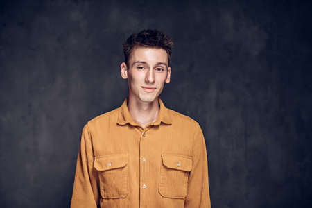 Smiling young caucasian man on dark backgroundの写真素材