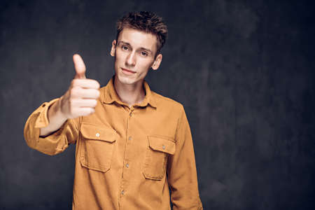 caucasian man show thumb up on dark backgroundの写真素材