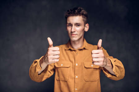 caucasian man show thumbs up on dark backgroundの写真素材