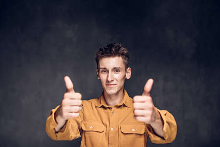caucasian man show thumbs up on dark backgroundの写真素材