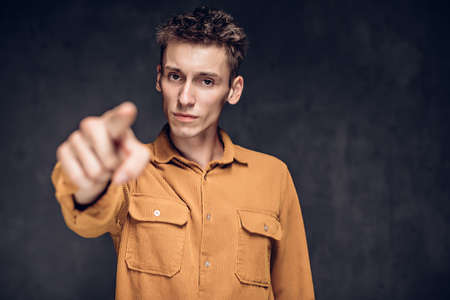 caucasian man point with finger on dark backgroundの写真素材