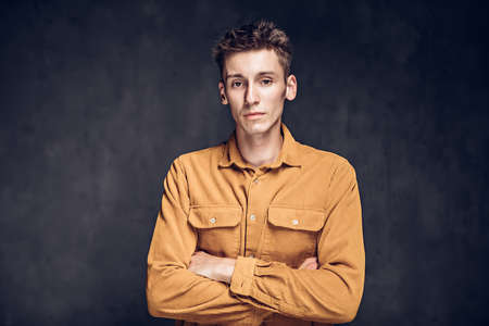 caucasian man with crossed arms on dark backgroundの写真素材