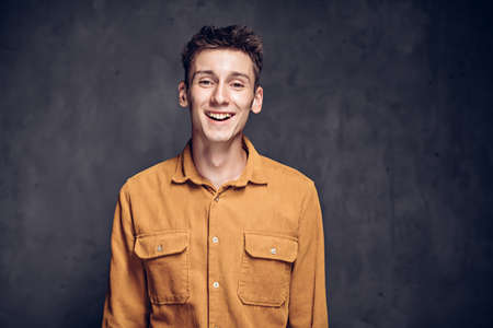 Happy young caucasian man on dark backgroundの写真素材