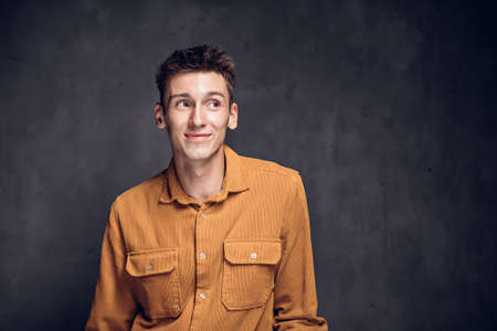 Joyful young caucasian man on dark backgroundの写真素材
