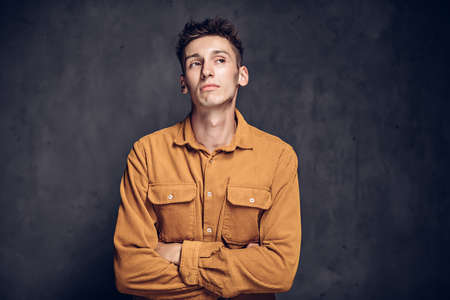 Pensive young caucasian man on dark backgroundの写真素材
