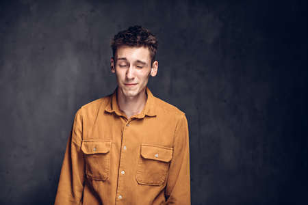 caucasian man with closed eyes on dark backgroundの写真素材