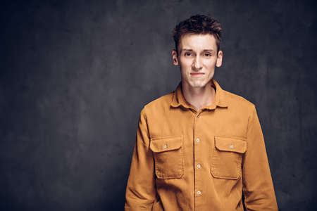 Stressed young caucasian man on dark backgroundの写真素材