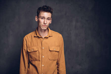 Sad young caucasian man on dark backgroundの写真素材
