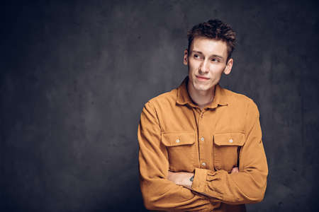 Sly young caucasian man on dark backgroundの写真素材
