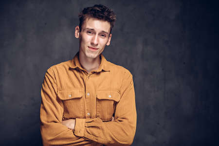 young man with skeptical face on dark backgroundの写真素材