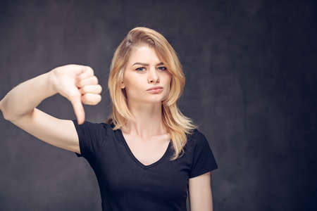 Young caucasian woman show thumb downの写真素材