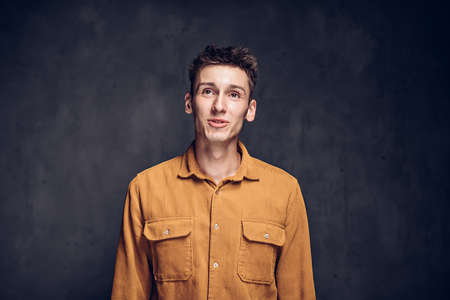 Positive young caucasian man on dark backgroundの写真素材
