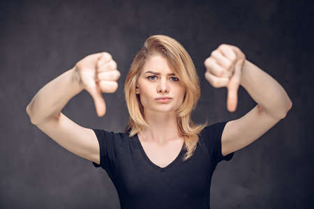 Young caucasian woman show thumbs downの写真素材