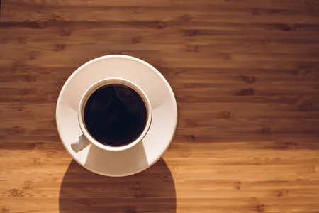 Cup of black coffee on bamboo deskの写真素材